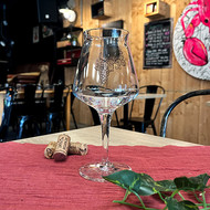 Verre Teku sérigraphié d'une grappe de raisin sur une table de bar à vin