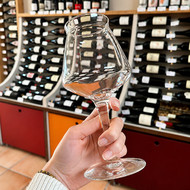 Verre Teku vierge tenu en main dans une cave à vin