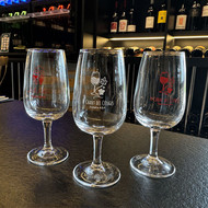 Trois verres Viticole 12 sérigraphiés au logo d'un domaine, sur un comptoir de caviste