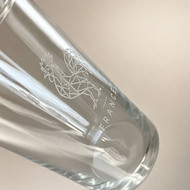 Gros plan d'une gravure de coq géométrique sur un verre Conical 42