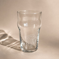 Verre Nonic 28,5 gravé d'un médaillon décoratif, sur fond beige