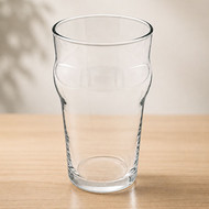 Verre Nonic 28,5 vierge posé sur une table en bois