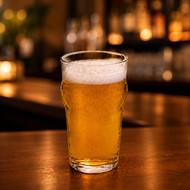 Verre Nonic 28,5 sans marquage rempli de bière blonde dans un bar