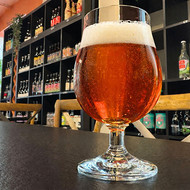 Verre Luettich vierge rempli de bière ambrée dans une cave à bières