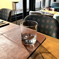 Verre Side vierge sur un set en cuir, devant une banquette à motifs