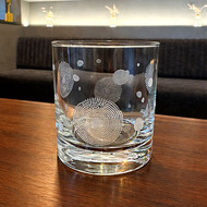 Verre Oria gravé posé sur une table basse dans un salon