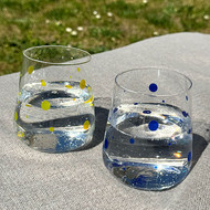 Verres San Diego jaune et bleu remplis d'eau, sur une table au jardin