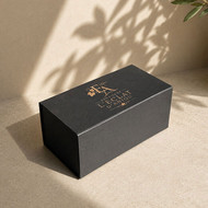 Boîte cadeau longue noire marquée du logo doré d'un domaine viticole