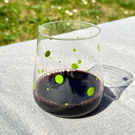 Verre San Diego vert clair rempli de vin rouge, sur une table au jardin